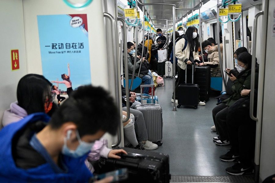 Passengers take a subway train with their luggage in Beijing, China, on 19 January 2023. (Wang Zhao/AFP)