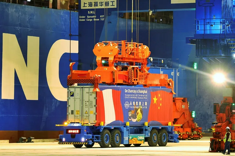 A worker walks next to a container at China’s state-owned COSCO Shipping Chancay port inaugurated during the APEC summit, in Chancay, Peru, in this handout image released on 14 November 2024. (APEC Peru/Handout via Reuters)