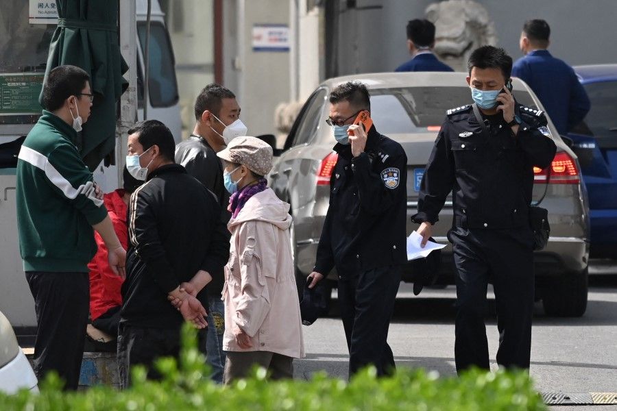 Police officers are seen at the Changfeng Hospital in Beijing on 19 April 2023, after a fire broke out a day earlier. (Greg Baker/AFP)