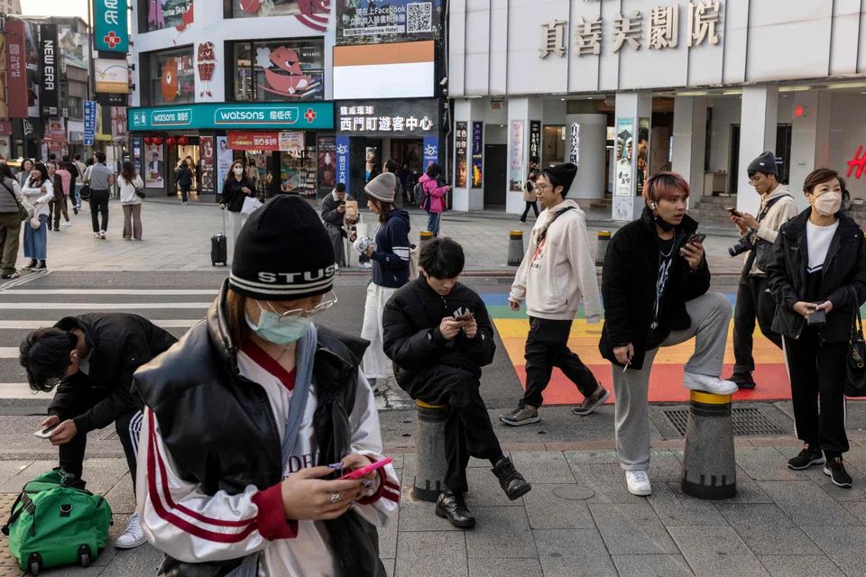 People walk at Ximending shopping district in Taipei on 10 January 2024. (Alastair Pike/AFP)