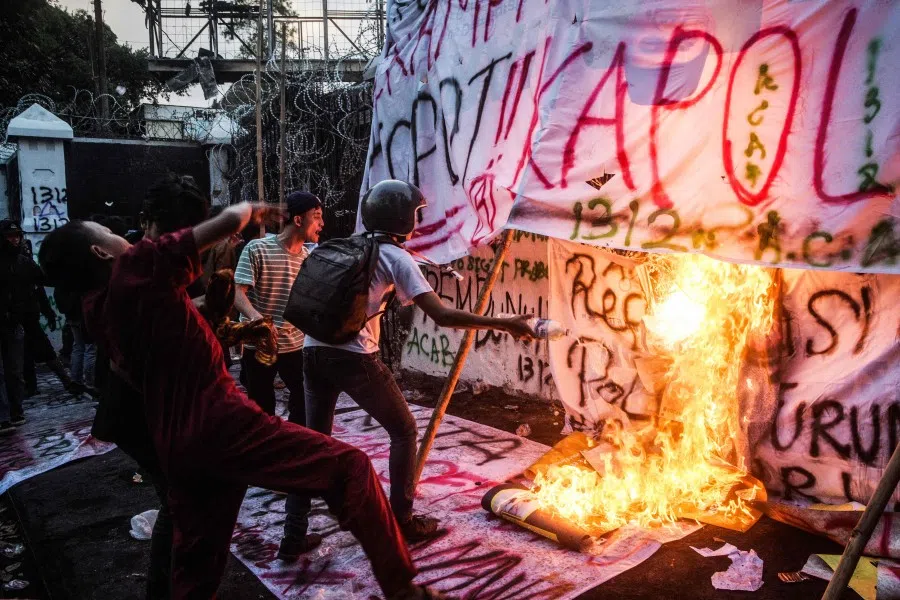 Demonstrators set alight banners as they shout slogans during a protest demanding police reform and the dissolution of the parliament, in Bandung, West Java on 1 September 2025. (Timur Matahari/AFP)