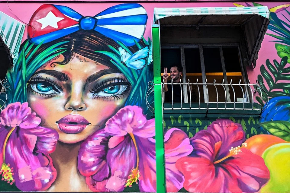 A man cheers to people marching through the streets of Miami, Florida, to commemorate last year's historic protests in Cuba on 11 July 2022. (Chandan Khanna/AFP)