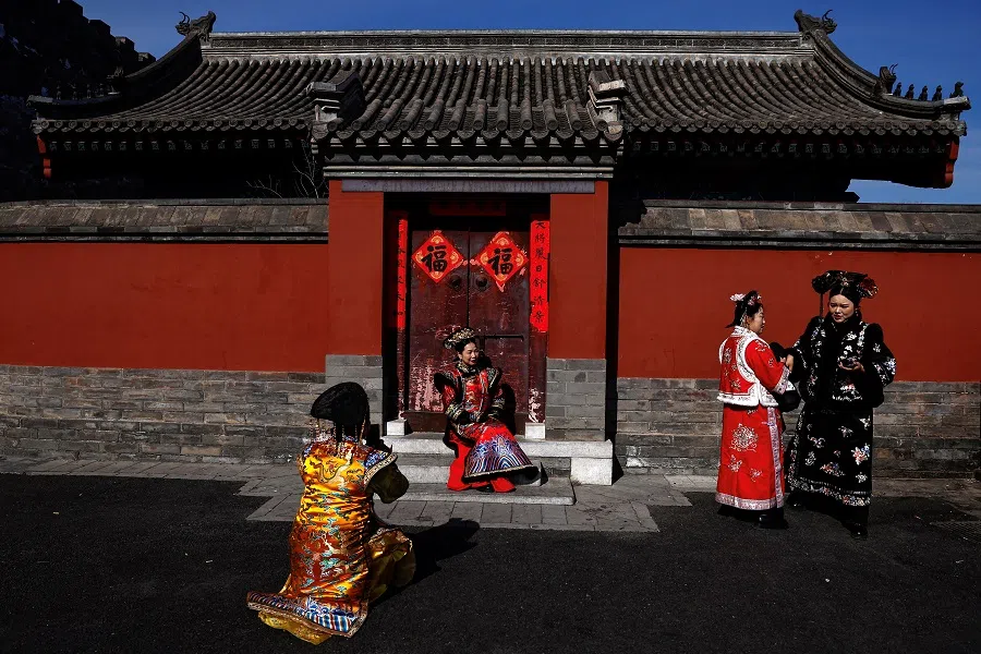 2025年2月21日，一名身着中国传统服饰的女子在中国北京故宫外摆姿势拍照。（王廷舒/路透社）