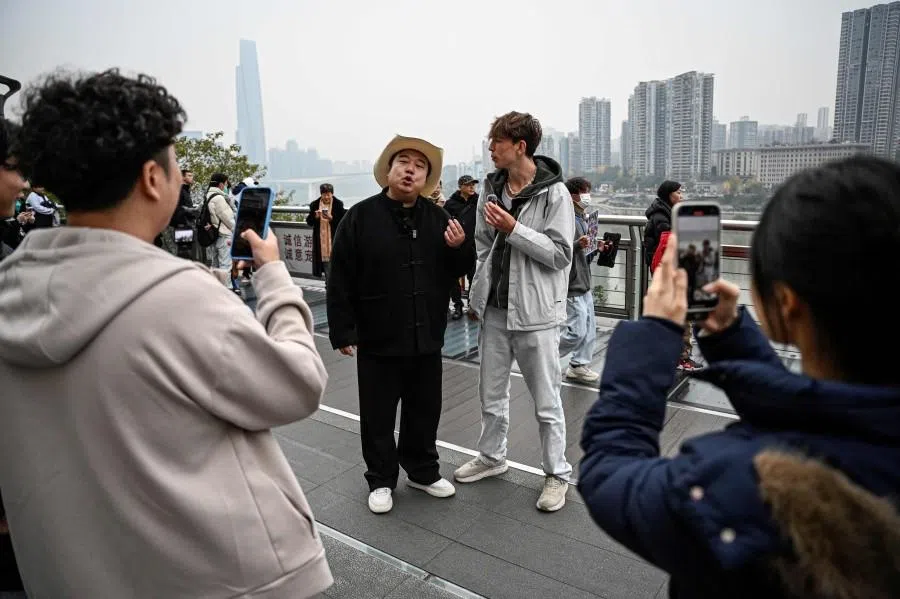 This photo taken on 15 December 2025 shows Donald Trump impersonator Ryan Chen interacting with fans along a street in southwestern China’s Chongqing municipality. (Jade Gao/AFP)