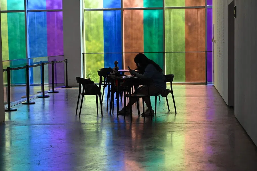 A woman checks her phone at an art museum in Beijing on 20 August 2021. (Jade Gao/AFP)