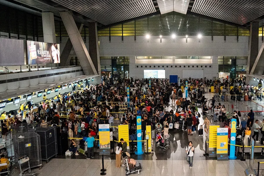 Passengers queue at airline counters at the Ninoy Aquino International Airport, Metro Manila, Philippines, on 19 July 2024. (Lisa Marie David/Reuters)