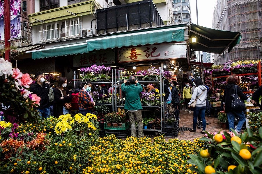 People walk through the flower market in Hong Kong, China, on 12 January 2023 ahead of the Lunar New Year of the Rabbit. (Isaac Lawrence/AFP)