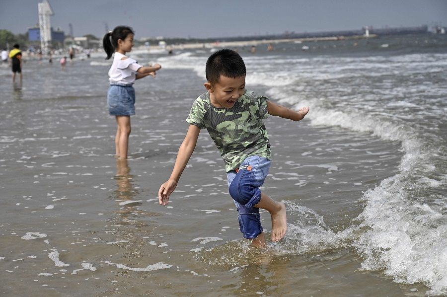 Children play on a beach in Qinhuangdao, Hebei province, China, on 4 July 2021. (Jade Gao/AFP)