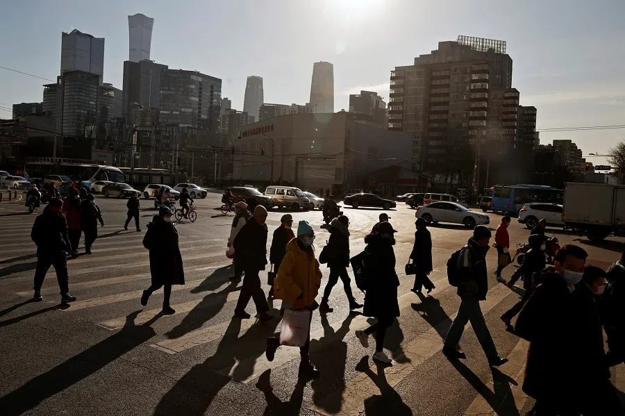 People cross a street during morning rush hour in the central business district (CBD) in Beijing, China, 15 December 2020. (Thomas Peter/Reuters)
