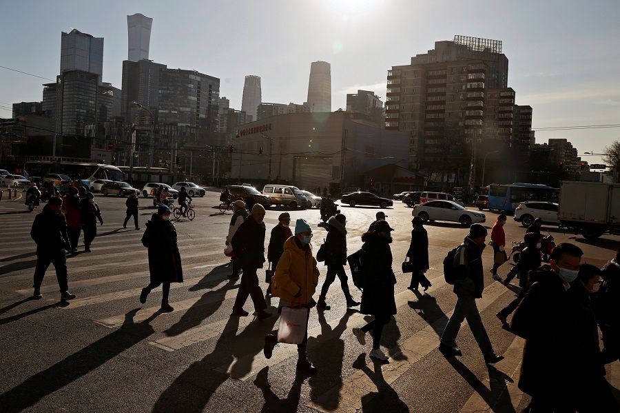 People cross a street during morning rush hour in the central business district (CBD) in Beijing, China, 15 December 2020. (Thomas Peter/Reuters)
