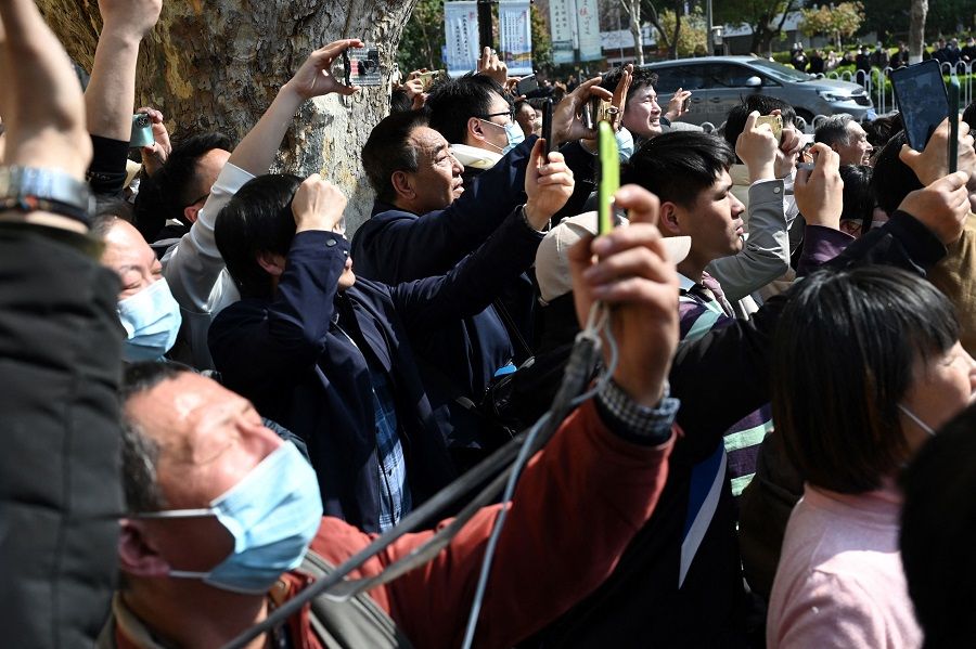 People wave as the motorcade of former Taiwan president Ma Ying-jeou arrives at the Museum of Modern Chinese History in Nanjing, Jiangsu province, China, on 28 March 2023. (Greg Baker/AFP)