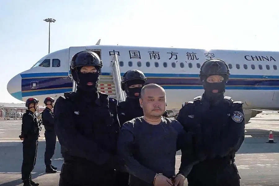 This frame grab from a handout video released by the Chinese Ministry of Public Security on 1 April 2026, shows China-born accused scam boss Li Xiong arriving at an airport in handcuffs and escorted off a China Southern Airlines plane. He was extradited from Cambodia, Chinese state media said, linking him to an alleged kingpin indicted by the US for running a multibillion-dollar cyberscam network from the Southeast Asian nation.