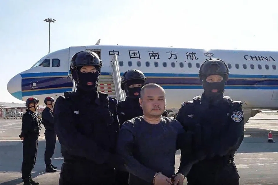 This frame grab from a handout video released by the Chinese Ministry of Public Security on 1 April 2026, shows China-born accused scam boss Li Xiong arriving at an airport in handcuffs and escorted off a China Southern Airlines plane. He was extradited from Cambodia, Chinese state media said, linking him to an alleged kingpin indicted by the US for running a multibillion-dollar cyberscam network from the Southeast Asian nation. (AFP)