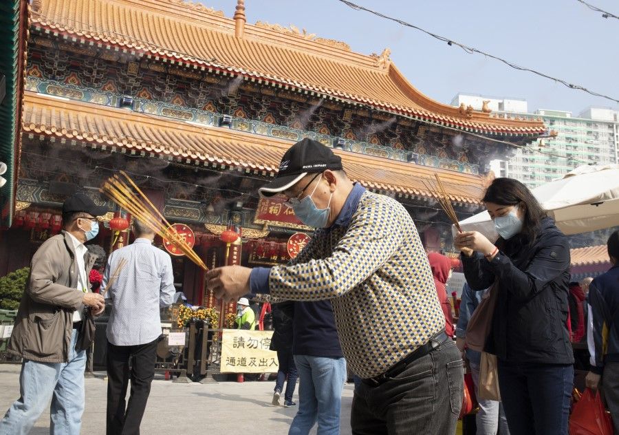 People wear face masks while praying at Wong Tai Sin Temple, Hong Kong, on 28 January 2021. (iStock)