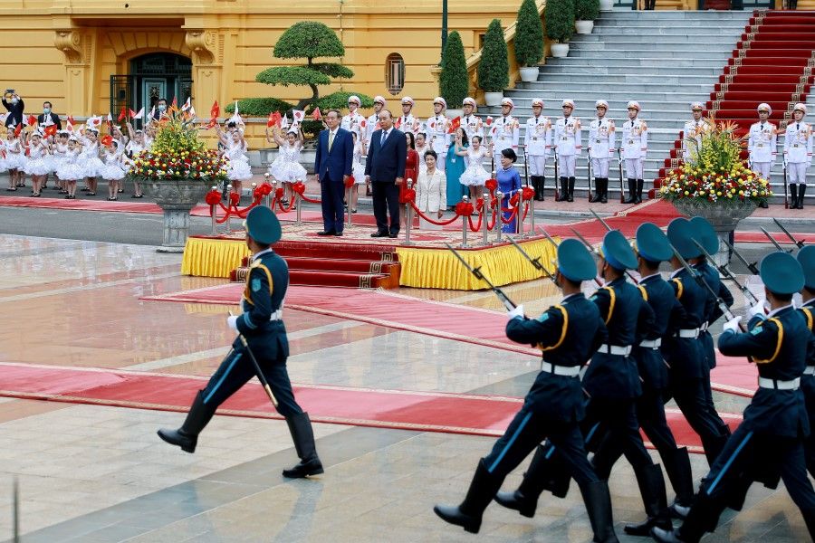 The "Yellow House", Vietnam's Presidential Palace in Hanoi, is seen in the background during a visit by Japanese Prime Minister Yoshihide Suga (left) and his Vietnamese counterpart Nguyen Xuan Phuc (right) in Hanoi, Vietnam, 19 October 2020. (Minh Hoang/Pool via REUTERS)