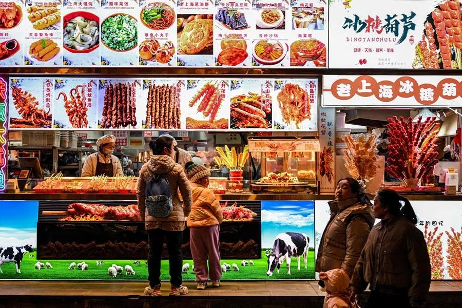 People buy food items at a restaurant at Yu Garden in Shanghai on 21 January 2026. (Hector Retamal/AFP)