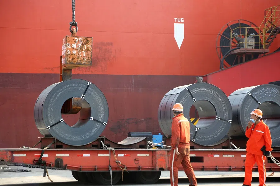 Workers wearing face masks following the coronavirus outbreak load steel products for export to a cargo ship at a port in Lianyungang, Jiangsu, China, on 27 May 2020. (China Daily via Reuters)