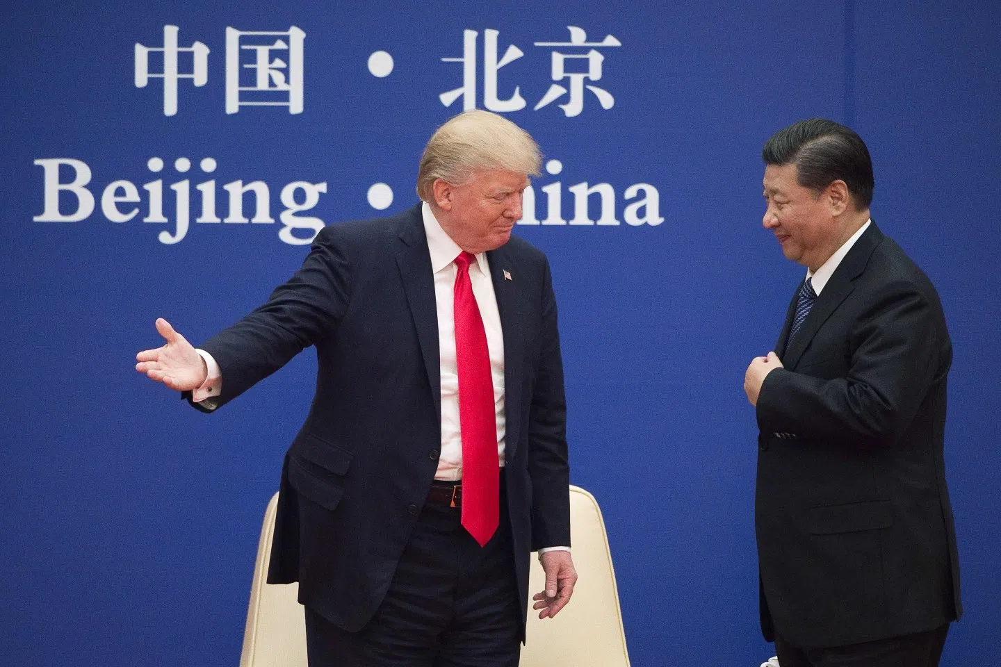 In this file photo taken on 8 November 2017, US President Donald Trump (left) gestures next to China’s President Xi Jinping during a business leaders event at the Great Hall of the People in Beijing. (Nicolas Asfouri/AFP)