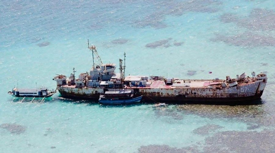 This undated handout photo received from the Department of National Defence (DND) of the Philippines on 24 November 2021 shows two civilian supply boats anchored at the derelict navy vessel Sierra Madre, shortly after arriving at Second Thomas shoal in the contested Spratly Islands. (Handout/Department National Defense Philippines (DND)/AFP)