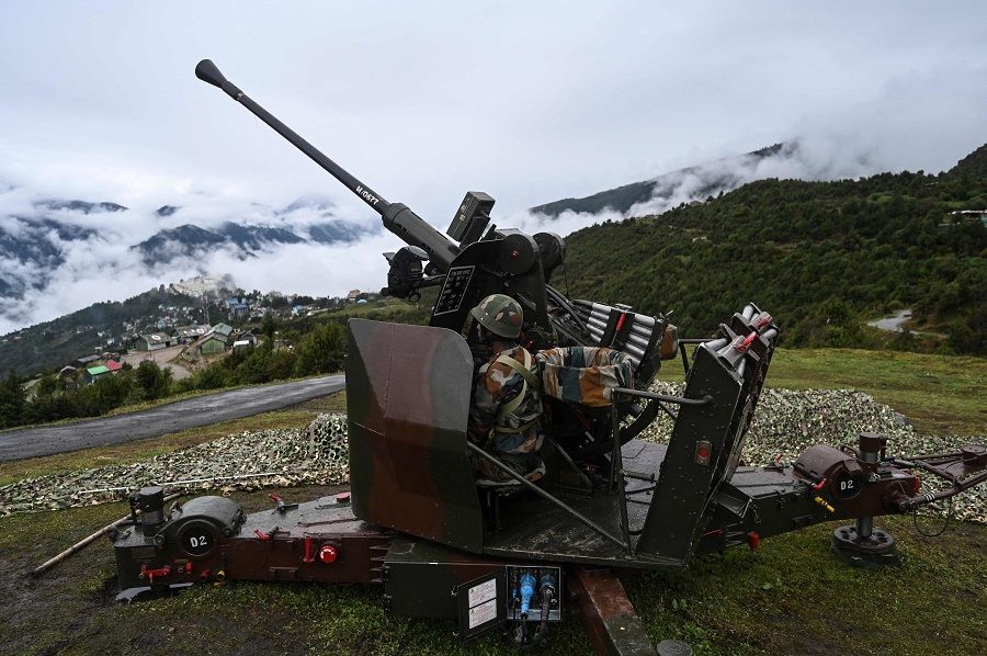 An Indian Army soldier sits inside an upgraded L70 anti-aircraft gun in Tawang, near the Line of Actual Control (LAC), in the Indian state of Arunachal Pradesh on 20 October 2021. (Money Sharma/AFP)