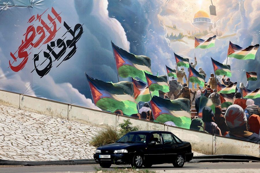 A car drives past a giant poster depicting the "Operation Al-Aqsa Flood" in Beirut, Lebanon on 2 November 2023. (Joseph Eid/AFP)