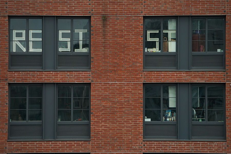A message to "Resist" is seen in the windows of an apartment building in the Williamsburg section of Brooklyn on 25 March 2020 in New York. (Bryan R. Smith/AFP)