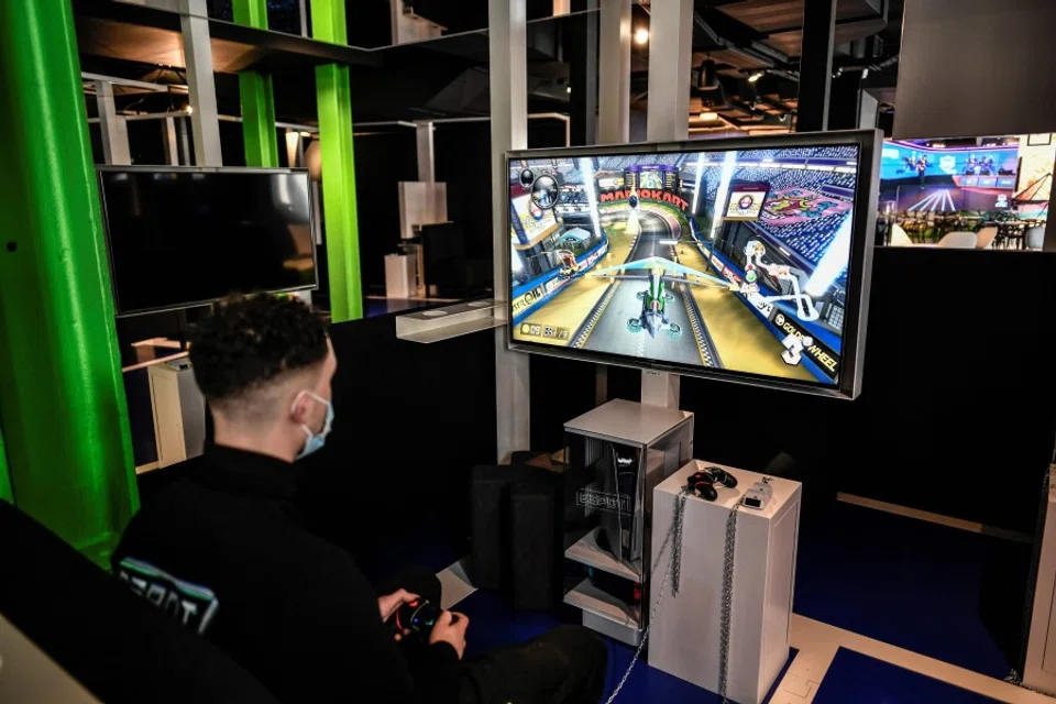 An employee plays a video game at the Espot gaming centre in Paris, on 31 May 2021. (Stephane de Sakutin/AFP)