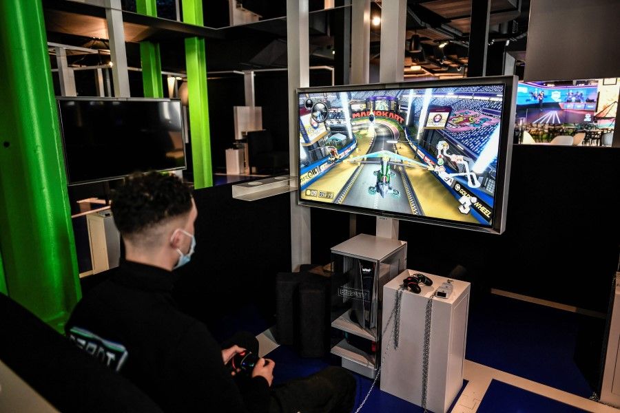 An employee plays a video game at the Espot gaming centre in Paris, on 31 May 2021. (Stephane de Sakutin/AFP)