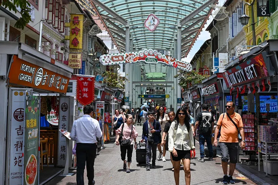 People walk along a pedestrian street in the Chinatown district of Singapore on 7 October 2024. (Roslan Rahman/AFP)