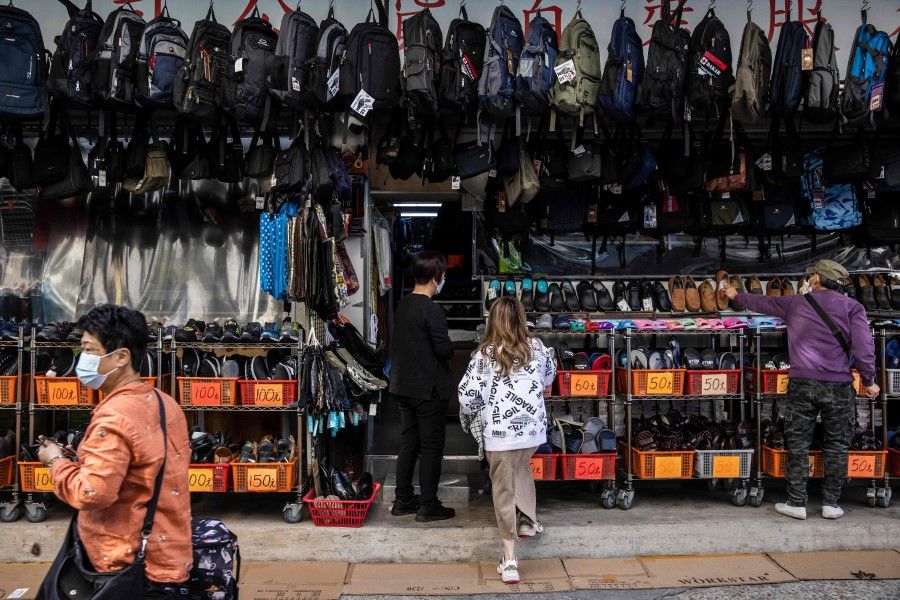 People look at a store selling bags and shoes in Sheung Shui in Hong Kong on 6 January 2023, a border district next to mainland China. (Isaac Lawrence/AFP)