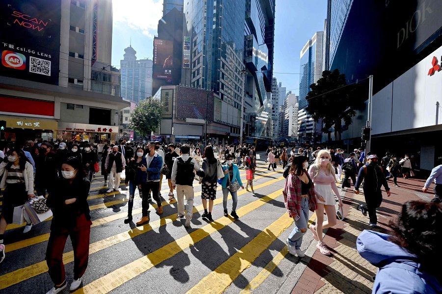 Pedestrians cross a busy intersection in Causeway Bay in Hong Kong on 4 January 2022. (Peter Parks/AFP)