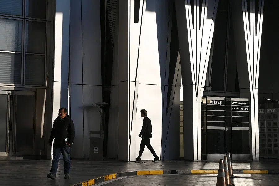 People walk outside an office tower and shopping mall in Beijing, China, on 8 December 2024. (Greg Baker/AFP)