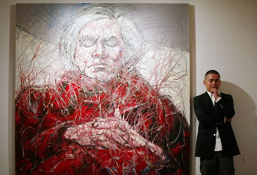 Chinese contemporary artist Zeng Fanzhi poses with his artwork. (SPH Media)
