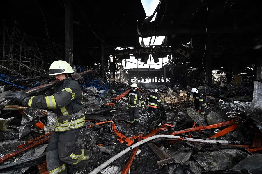 Rescuers clear the rubble of a warehouse in the town of Brovary, north of Ukrainian capital of Kyiv, after being destroyed by a Russian rocket strike and shelling, on 29 March 2022. (Genya Savilov/AFP)