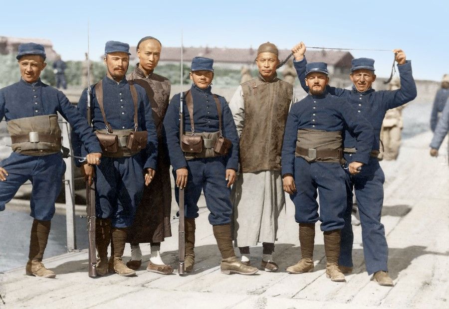 French troops with two Chinese in Beijing, 1900. The French soldier on the right intentionally lifts the queue of the Chinese as a joke. China was weak and allowed itself to be bullied by Western powers. The Chinese in the middle does not even know the French soldier's action was a mockery of his appearance, showing a real psychological weakness.