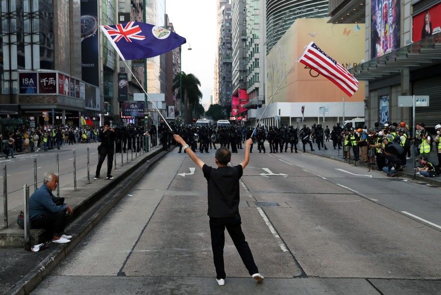 A protester waves a US and a colonial Hong Kong flag at a rally in Hong Kong. (Leah Millis/REUTERS)