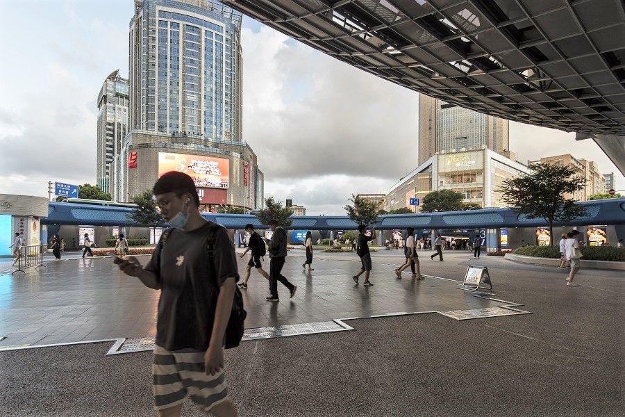 Pedestrians walk through a plaza in Shanghai, China on 20 July 2021. (Qilai Shen/Bloomberg)