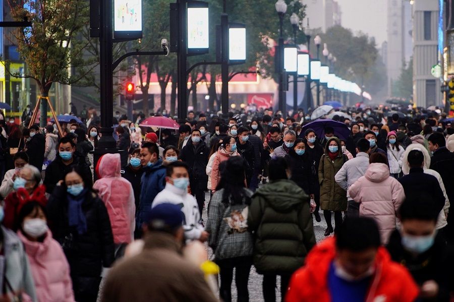 People wearing face masks are seen at a shopping area in Wuhan, Hubei province, China, 6 December 2020. (Aly Song/Reuters)