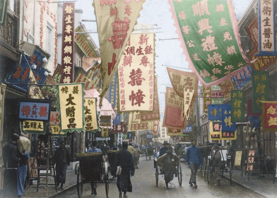During the days of the Republic, Henan Road in Shanghai was part of the British concession. In this picture, rickshaws ply the streets with passengers, while giant banners hang along the streets.