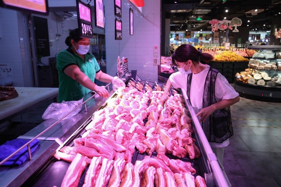 A shopper buys pork in a supermarket in Wuchuan, Guizhou, 30 September 2022 (Hong Kong China News Agency)