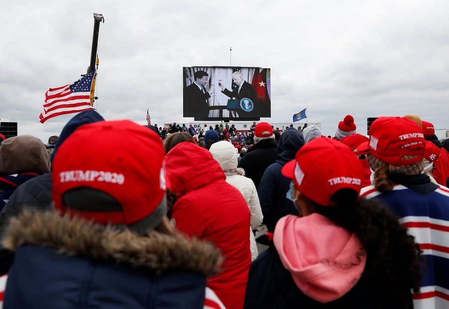 Democratic US presidential nominee Joe Biden and Chinese President Xi Jinping are seen on a screen as supporters of US President Donald Trump gather for a Trump re-election campaign rally in Waterford Township, Michigan, US, 30 October 2020. (Shannon Stapleton/Reuters)