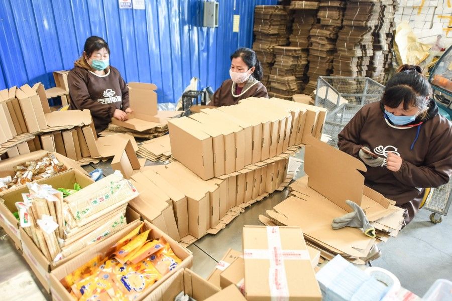 Employees package items to be delivered to online customers in Donghai in China's eastern Jiangsu province, April 27, 2020. (STR/AFP)