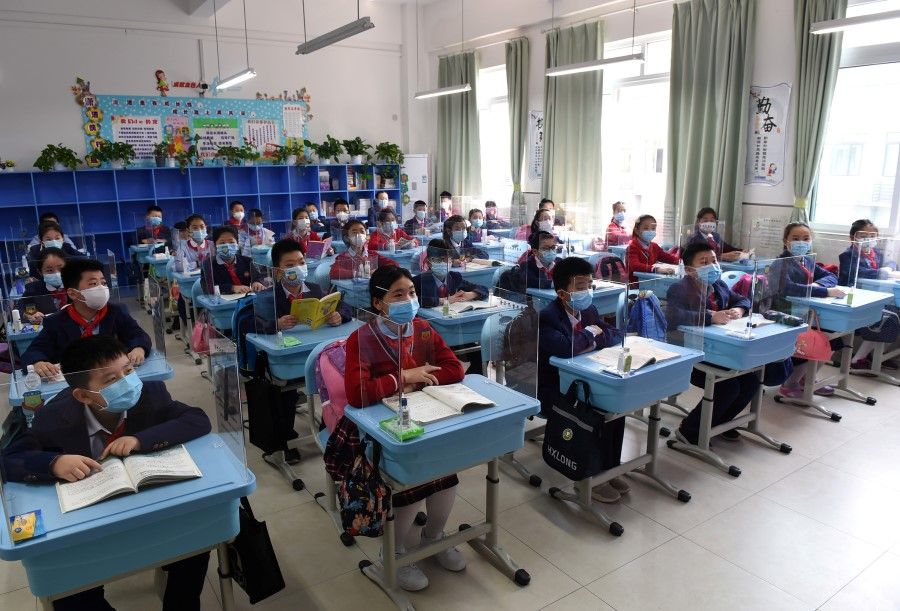 Students in a classroom with partitions on their desks as more students in Chongqing return to school following the coronavirus outbreak, 27 April, 2020. (CNS via REUTERS)