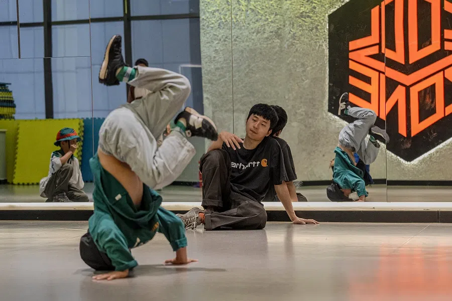 Su Jie, Zhuangzhuang’s breaking coach, instructs Zhuangzhuang on his postures.
