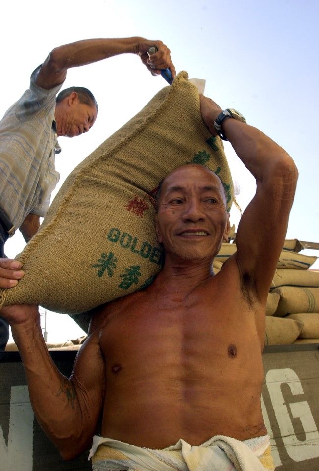 A man has a sack of rice loaded on his shoulder for delivery. (SPH Media)
