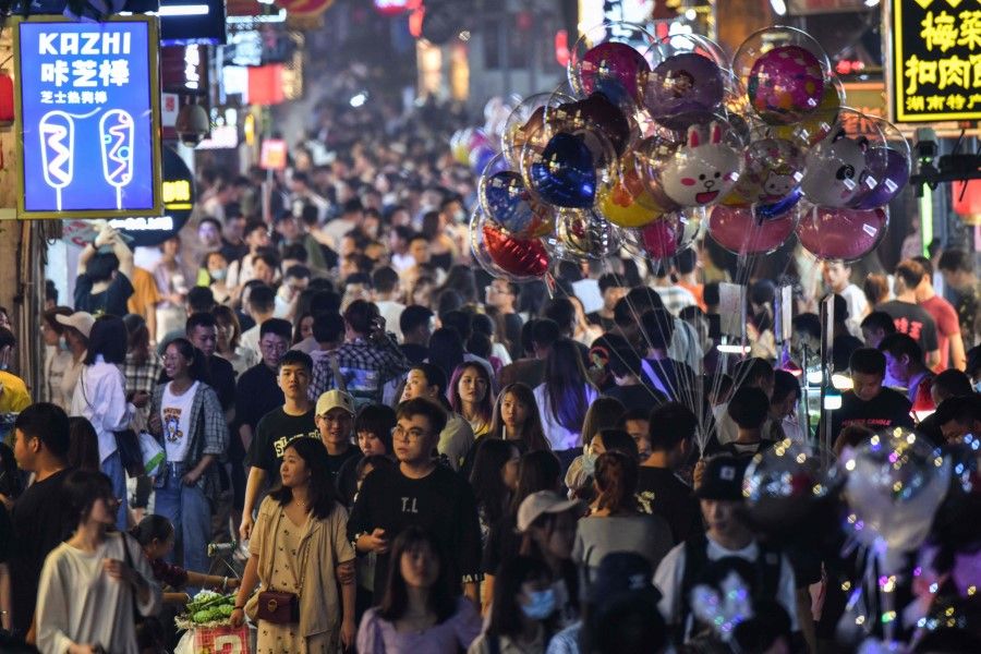 Pedestrians in a crowded street surrounded by small shops in the city of Changsha, China's Hunan province, 7 September 2020. (Hector Retamal/AFP)