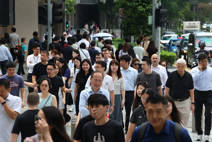 Pedestrians walk along a street in Singapore, April 2026.