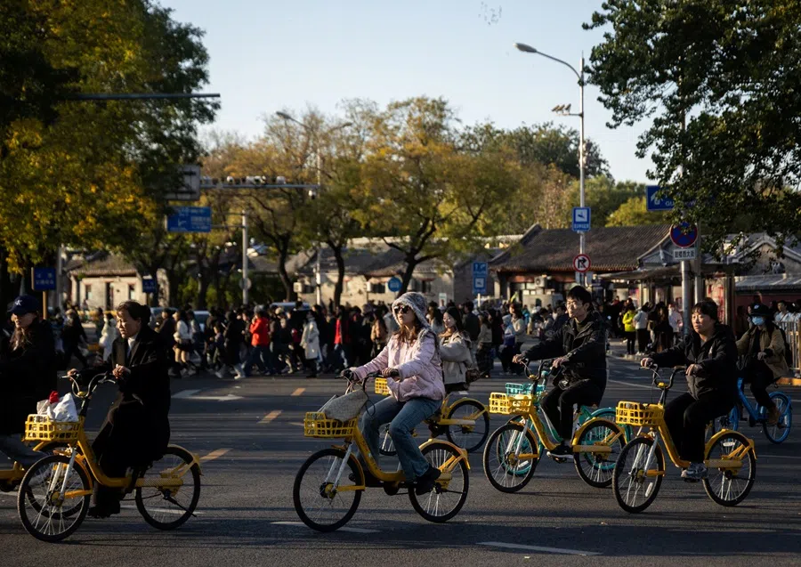 People ride bikes on a sunny autumn day in Beijing, China, on 9 November 2025. (​Maxim Shemetov/Reuters)