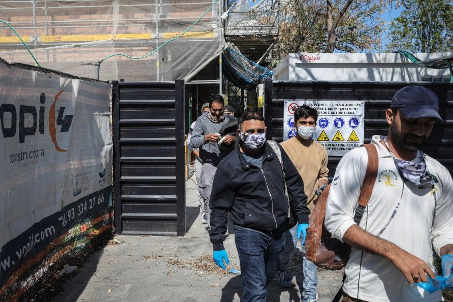 Workers exit a construction site in Barcelona, Spain, April 14, 2020. Spain has already overcome the peak of the coronavirus epidemic and will now focus on bending the infection curve, according to Health Minister Salvador Illa. (Angel Garcia/Bloomberg)