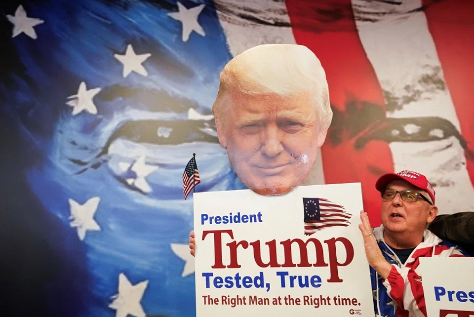 A supporter holds up a sign in Manchester, New Hampshire, US, on 20 January 2024. (/Kevin Lamarque/Reuters)